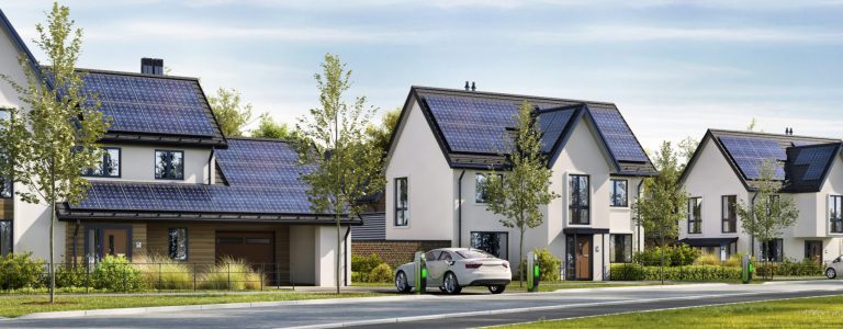 Road and beautiful houses with solar panels on the roof. Charging stations and electric cars